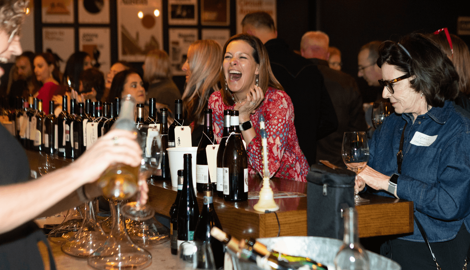 A woman laughing at a Cellar wine tasting event